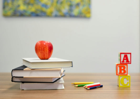 Kids writing at a classroom desk with paper and pencils — letter writing in school